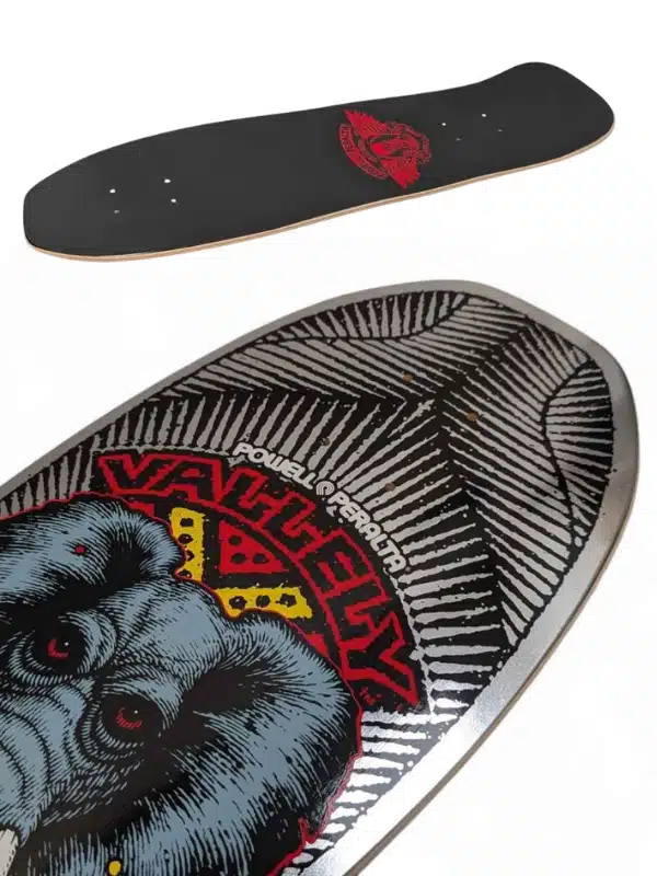 Two skateboard decks: a plain black deck with a red logo, and a close-up graphic deck featuring an ape head and Powell-Peralta branding.